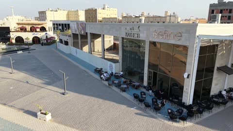 مكان للتسوق وقضاء وقت ممتع، مركز ترفيهي وتجاري، الفن الهندسي المعماري على الطراز الحديث والمتطور في المملكة العربية السعودية، المطاعم والمقاهي والمراكز التجارية المميزة، تصوير درون لمجمع ماي ووك في شارع عمرو بن العاص في حي المصيف بمدينة تبوك في وقت النهار