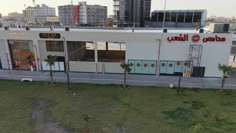 مركز ترفيهي وتجاري، الفن الهندسي المعماري على الطراز الحديث والمتطور في المملكة العربية السعودية، المطاعم والمقاهي والمراكز التجارية المميزة، تصوير درون لمجمع ماي ووك في شارع عمرو بن العاص في حي المصيف بمدينة تبوك في وقت النهار، مكان للتسوق وقضاء وقت ممتع