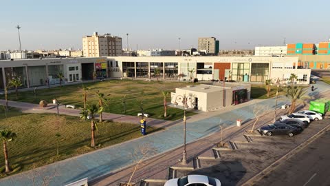 مكان للتسوق وقضاء وقت ممتع، مركز ترفيهي وتجاري، الفن الهندسي المعماري على الطراز الحديث والمتطور في المملكة العربية السعودية، المطاعم والمقاهي والمراكز التجارية المميزة، تصوير درون لمجمع ماي ووك في شارع عمرو بن العاص في حي المصيف بمدينة تبوك في وقت النهار