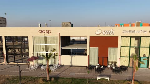 مكان للتسوق وقضاء وقت ممتع، مركز ترفيهي وتجاري، الفن الهندسي المعماري على الطراز الحديث والمتطور في المملكة العربية السعودية، المطاعم والمقاهي والمراكز التجارية المميزة، تصوير درون لمجمع ماي ووك في شارع عمرو بن العاص في حي المصيف بمدينة تبوك في وقت النهار