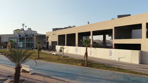 مركز ترفيهي وتجاري، الفن الهندسي المعماري على الطراز الحديث والمتطور في المملكة العربية السعودية، المطاعم والمقاهي والمراكز التجارية المميزة، تصوير درون لمجمع ماي ووك في شارع عمرو بن العاص في حي المصيف بمدينة تبوك في وقت النهار، مكان للتسوق وقضاء وقت ممتع