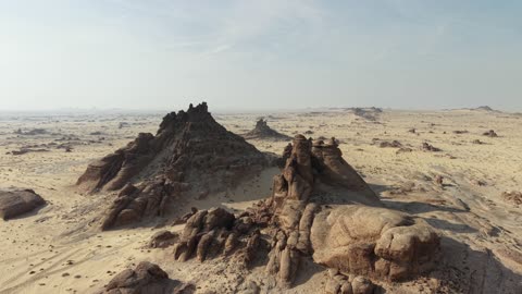 A depiction of mountains with rock formations in the Tayma region of the Kingdom of Saudi Arabia, natural landscapes of golden sands, and cultural tourist landmarks in the Kingdom of Saudi Arabia.