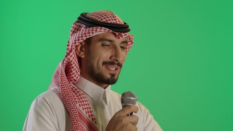 عقد ندوة تعليمية، بورتريه لشاب عربي خليجي سعودي يرتدي الثوب التقليدي والشماغ  يحمل بيده مكبر الصوت و ورقة بيضاء يقوم بإلقاء الخطاب، خلفية خضراء، كروما