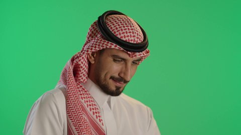 التطور و التكنولوجيا الحديثة، ادارة الأعمال عن بعد، بورتريه لرجل عربي خليجي سعودي يرتدي الثوب التقليدي والشماغ يستخدم التابلت، وظائف ومهن سعودية، خلفية خضراء، كروما