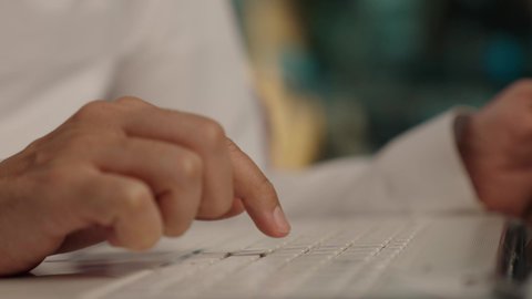 بورتريه مقرب ليد رجل عربي خليجي سعودي يرتدي الزى التقليدي يقوم بالنقر على جهاز الحاسوب المحمول، دمج التقنيات المتطوره فى الحياه اليوميه، وظائف ومهن سعودية