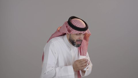 الإصابة بالزكام والتعب والمرض, بورترية لرجل عربي خليجي سعودى يرتدي الثوب والشماغ يمسك المنديل بيديه ويغطي أنفه، ظهور أعراض الانفلونزا والعطاس بشكل متكرر، ضرورة الحصول على الراحة وأخذ العلاج المناسب، خلفية بيضاء