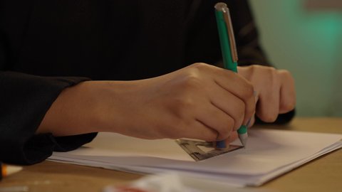 النهضة في مجال الإنشاءات الهندسية في الخليج, مساهمة المرأة في تطورالقطاع الهندسي, تصوير مقرب ليد مهندسة عربية خليجية سعودية تجلس على المكتب تمسك بيدها قلم لإكمال رسم المخطط المعماري، متابعة استراتيجات المشروع