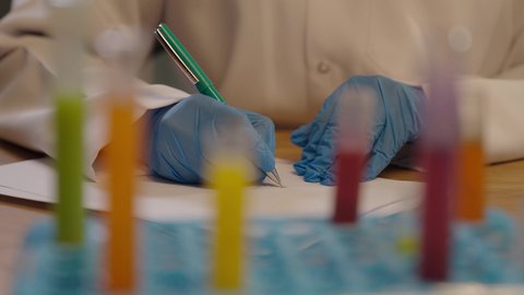 تدوين نتائج الفحوصات الطبية، تحاليل تشخيصية كيميائية، طبيبة مخبرية خليجية ترتدي القفازات الطبية، استخدام الانابيب الزجاجية لتحليل العينات المختلفة ،اخصائية الطب المخبري، مهن و وظائف نسائية