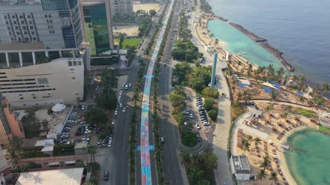 A view of the city of Jeddah in the Kingdom of Saudi Arabia during the daytime, the waterfront on the shores of the Red Sea, coastal tourist spots in Saudi Arabia, an aerial view of the towers and skyscrapers along the Jeddah Corniche.