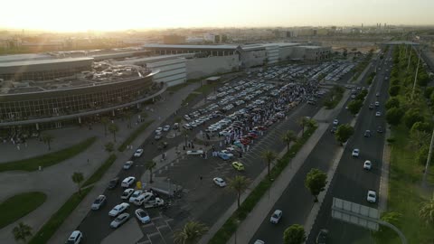 تصوير درون لصفوف المركبات بالماركات العالمية المختلفة في مكان لاستعراض السيارات في محافظة تبوك، سوق بيع وشراء السيارات المستعملة، حركة التجارة الداخلية في المملكة العربية السعودية، جذب الزبائن والمستهلكين عن طريق طريقة عرض السيارة المميزة