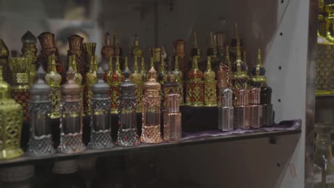 The bottles feature designs rich in details and traditional engravings, showcasing Arab heritage, made from various materials such as glass and metals in diverse colors including gold and silver, with a variety of shapes ranging from cylindrical to bulbous, selling traditional Arabic perfumes such as oud and frankincense.