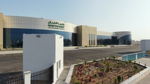 Drone photography of the Exhibition and Conference Center in Tabuk Province, the main roads and streets, the improvement and preparation of buildings and economic facilities in the Kingdom of Saudi Arabia, modern architectural engineering art.
