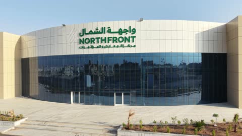 Drone photography of the Exhibition and Conference Center in Tabuk Province, the main roads and streets, the improvement and preparation of buildings and economic facilities in the Kingdom of Saudi Arabia, modern architectural engineering art.