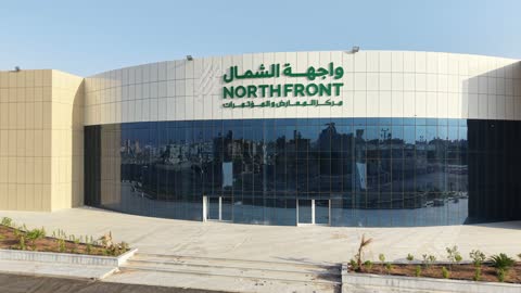 Improving and preparing economic buildings and facilities in the Kingdom of Saudi Arabia, drone photography of the Exhibition and Conference Center in Tabuk Province, main roads and streets, architectural engineering art in the modern style.