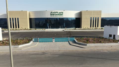 Drone photography of the Exhibition and Conference Center in Tabuk Province, the main roads and streets, the improvement and preparation of buildings and economic facilities in the Kingdom of Saudi Arabia, modern architectural engineering art.