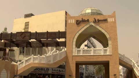 The gate of Muttrah Souq in the Sultanate of Oman, the art of engineering and ancient architectural design, famous tourist attractions, brightly colored illuminated lamps, popular markets, heritage archaeological sites, colorful decorations and engravings, shopping and purchasing, famous landmarks, shops for traditional handicrafts in Muttrah Souq.