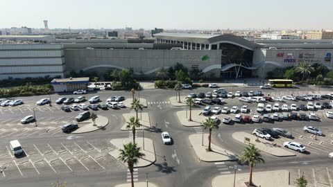 A prominent family shopping and entertainment destination, drone footage of Park Mall on King Faisal Road in the Prince Murooj neighborhood in the city of Tabuk, modern architectural design, places to enjoy quality time with family in the Kingdom of Saudi Arabia.