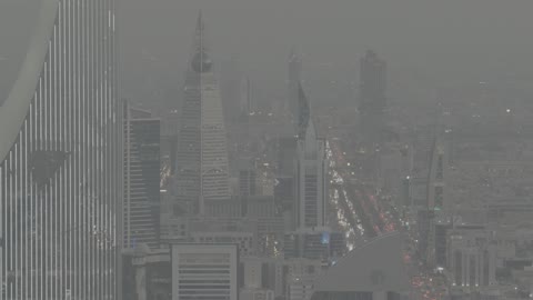 Famous tourist areas and landmarks, traffic flow on the public road, aerial drone photography of King Fahd Road in Riyadh, towers and skyscrapers in the Kingdom, architectural engineering art in the Kingdom of Saudi Arabia, foggy atmosphere.