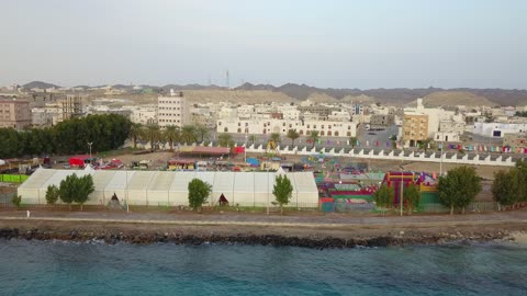 مدينة العاب وملاهي للأطفال، من أكبر محافظات تبوك من حيث المساحة، مركزاً تجارياً هاماً بعد مكة المكرمة، الموقع على ساحل البحر الأحمر بين مدينتي الوجه وينبع، أملج الساحلية في السعودية،  تصوير درون لمياه البحر في أملج في المملكة العربية السعودية