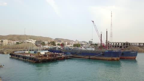 حركة السفن والموانئ، من أكبر محافظات تبوك من حيث المساحة، مركزاً تجارياً هاماً بعد مكة المكرمة، الموقع على ساحل البحر الأحمر بين مدينتي الوجه وينبع، أملج الساحلية في السعودية،  تصوير درون لمياه البحر في أملج في المملكة العربية السعودية