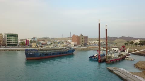 حركة السفن والموانئ، من أكبر محافظات تبوك من حيث المساحة، مركزاً تجارياً هاماً بعد مكة المكرمة، الموقع على ساحل البحر الأحمر بين مدينتي الوجه وينبع، أملج الساحلية في السعودية،  تصوير درون لمياه البحر في أملج في المملكة العربية السعودية