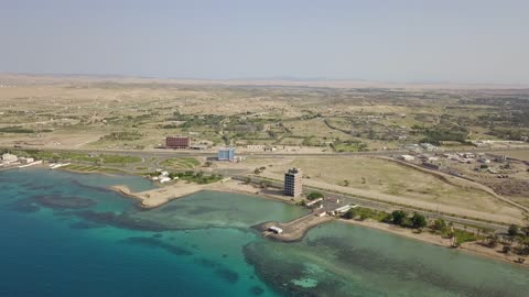 لون المياه البحر الفيروية، من أكبر محافظات تبوك من حيث المساحة، مركزاً تجارياً هاماً بعد مكة المكرمة، الموقع على ساحل البحر الأحمر بين مدينتي الوجه وينبع، أملج الساحلية في السعودية،  تصوير درون لمياه البحر في أملج في المملكة العربية السعودية