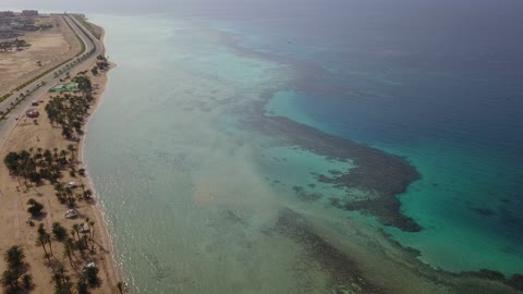 المياه الزرقاء الصافية، من أكبر محافظات تبوك من حيث المساحة، مركزاً تجارياً هاماً بعد مكة المكرمة، الموقع على ساحل البحر الأحمر بين مدينتي الوجه وينبع، أملج الساحلية في السعودية،  تصوير درون لمياه البحر في أملج في المملكة العربية السعودية