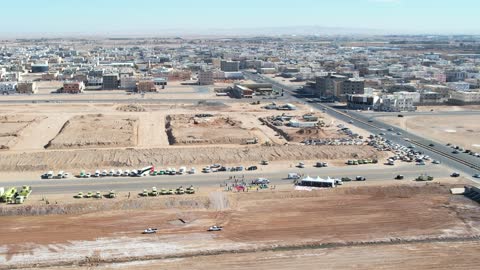 المعدات سيارة إسعافر، مخاريط مرورية لتنظيم الموقع، أفراد يرتدون زي المسعفين والأطباء، تدريباً أو مناورة طوارئ طبية في الهواء الطلق، تنظمها هيئة الهلال الأحمرفي المملكة العربية  السعودية أو جهة حكومية أخرى في المملكة العربية السعودية،  التعاون بين جهات متعددة