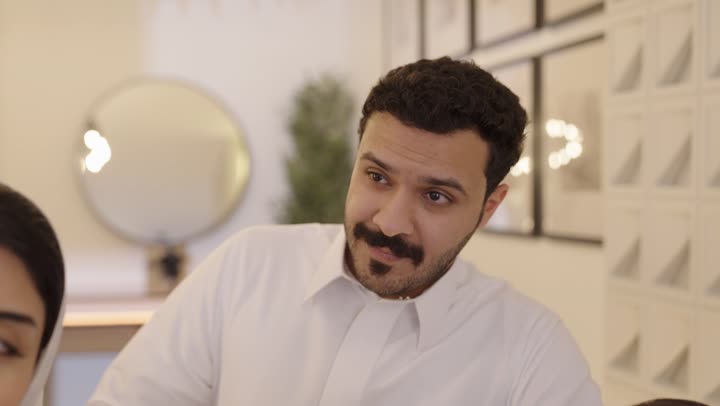 عائله عربيه خليجيه سعوديه  تقوم باجراء مكالمة فيديو جماعيه عبر الانترنت , التحدث مع الاصدقاء والاقارب عبرالهاتف المحمول، جو عائلي مرح، مفهوم الأسرة السعيدة، إستخدام جهاز تقني حديث