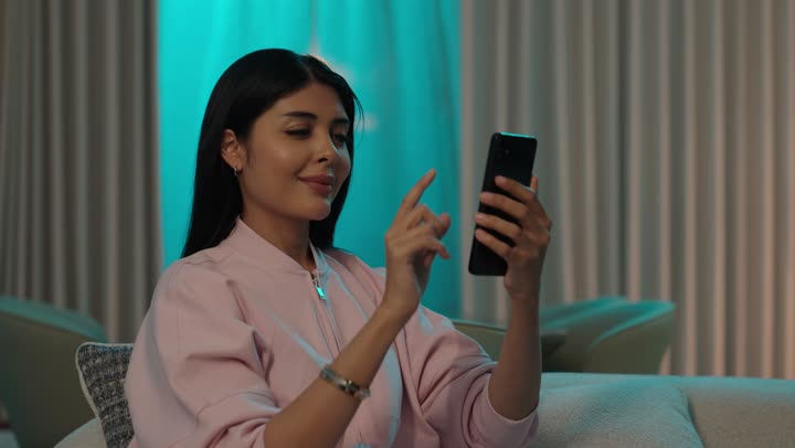 دمج التقنيات المتطورة في الحياه اليوميه, التواصل مع الأهل والأصدقاء عبر الجوال, أمرأة عربيه خليجيه سعودية ترتدي الزى الكاجوال تستخدم الهاتف المحمول