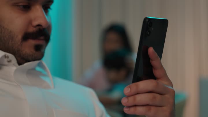 تصفح وسائل التواصل الاجتماعي عبر الجوال, استخدام الأجهزة التقنية الحديثة و المتطورة, رجل عربي خليجي سعودي يرتدي الثوب التقليدي يمسك الهاتف المحمول بيده