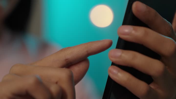 إنجاز المهام عن بعد، التواصل مع الأهل والأصدقاء عبرالجوال، يد أمرأة عربيه خليجيه سعودية ترتدي الزى الكاجوال تقوم باستخدام الهاتف، التسوق الالكتروني عبرالأونلاين، استخدام الأجهزة والتقنيات الحديثة والمتطورة