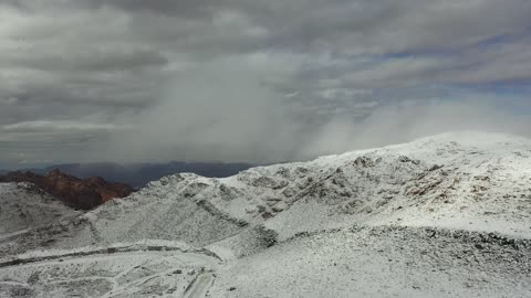 سلسلة جبال اللوز في منطقة تروجينا تكسوها الثلوج، جبال منحوتة وتشكيلات جبلية في مدينة تبوك، معالم حضارية سياحية في المملكة العربية السعودية،  تساقط الثلوج، منخفض جوي، أجواء شتوية، تصوير درون جوي للتكوينات الصخرية في قرية بجدة نيوم غرب المملكة العربية السعودية