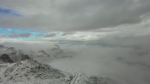 جبال منحوتة وتشكيلات جبلية في مدينة تبوك، معالم حضارية سياحية في المملكة العربية السعودية،  تساقط الثلوج، منخفض جوي، أجواء شتوية، سلسلة جبال اللوز في منطقة تروجينا تكسوها الثلوج، تصوير درون جوي للتكوينات الصخرية في قرية بجدة نيوم غرب المملكة العربية السعودية