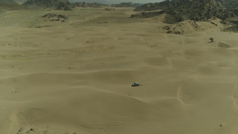 مغامرة سفاري على الكثبان الرملية في المملكة العربية السعودية, تصوير درون لسيارة ايسوزو ذات الدفع الرباعي الجبلية على رمال الصحراء الذهبية , التلال الرملية والتشكيلات والتكوينات الصخرية في الصحارى العربية, الأنشطة الترفيهية لقيادة السيارات في المناطق الصحراوية