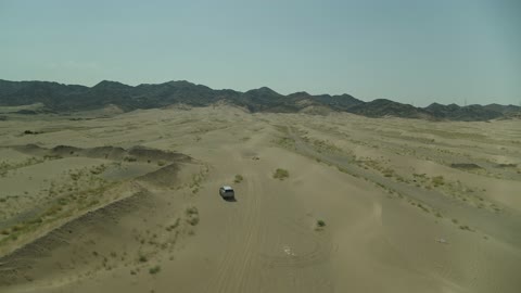 مغامرة سفاري على الكثبان الرملية في المملكة العربية السعودية, تصوير درون لسيارة ايسوزو ذات الدفع الرباعي الجبلية على رمال الصحراء الذهبية , التلال الرملية والتشكيلات والتكوينات الصخرية في الصحارى العربية, الأنشطة الترفيهية لقيادة السيارات في المناطق الصحراوية