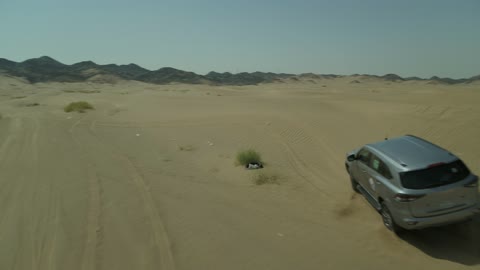 مغامرة سفاري على الكثبان الرملية في المملكة العربية السعودية, تصوير درون لسيارة ايسوزو ذات الدفع الرباعي الجبلية على رمال الصحراء الذهبية , التلال الرملية والتشكيلات والتكوينات الصخرية في الصحارى العربية, الأنشطة الترفيهية لقيادة السيارات في المناطق الصحراوية
