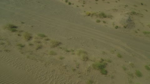 Recreational activities for driving cars in desert areas, a safari adventure on the sand dunes in the Kingdom of Saudi Arabia, drone photography of an Isuzu off-road vehicle on the golden desert sands, sand hills, and rock formations in the Arab deserts.