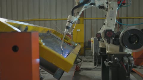 الاعتماد على التقنيات الحديثة والمتطورة في المملكة العربية السعودية، هندسات ومعدات صناعية، روبوت لحام صناعي على الطراز المتطور يقوم بالعمل في مصنع، روبوتات حديثة تساعد على زيادة الكفاءة والسرعة والدقة في خطوط الإنتاج