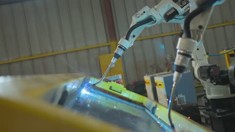 الاعتماد على التقنيات الحديثة والمتطورة في المملكة العربية السعودية، هندسات ومعدات صناعية، روبوت لحام صناعي على الطراز المتطور يقوم بالعمل في مصنع، روبوتات حديثة تساعد على زيادة الكفاءة والسرعة والدقة في خطوط الإنتاج