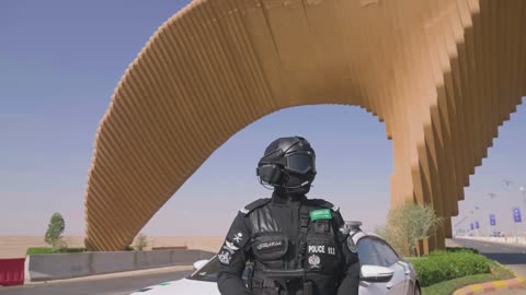 سيارة الشرطة الرسمية، شرطي عربي خليجي سعودي من قوات التدخل السريع () يرتدي البدلة العسكرية السوداء، الحفاظ على الأمن والأمان، الوقوف بإستقامة وإنضباط، قوات الشرطة في المملكة العربية السعودية