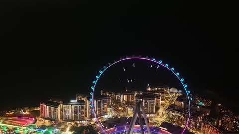 الأبراج وناطحات السحاب والمنشآت المطلة على البحر، تصوير درون لعجلة عين دبي في الامارات العربية المتحدة في وقت الليل، الوجهة البحرية على ساحل الخليج العربي، الفن الهندسي المعماري للمناطق والمعالم الترفيهية المشهورة