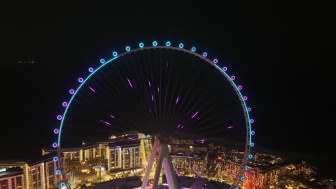 The towers, skyscrapers, and waterfront structures, drone footage of the Dubai Eye in the United Arab Emirates at night, the seaside destination on the Arabian Gulf coast, the architectural engineering art of famous areas and recreational landmarks.