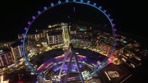 The towers, skyscrapers, and waterfront structures, drone footage of the Dubai Eye in the United Arab Emirates at night, the seaside destination on the Arabian Gulf coast, the architectural engineering art of famous areas and recreational landmarks.