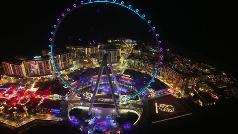 الأبراج وناطحات السحاب والمنشآت المطلة على البحر، تصوير درون لعجلة عين دبي في الامارات العربية المتحدة في وقت الليل، الوجهة البحرية على ساحل الخليج العربي، الفن الهندسي المعماري للمناطق والمعالم الترفيهية المشهورة