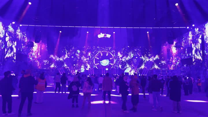 أجواء احتفالية ليلية، مهرجان غنائي  موسيقي عالمي حديث في ١٣ ديسمبر ٢٠٢٥ في المملكه العربيه السعوديه ،إضاءة بنفسجية وزرقاء قوية، مسرح ضخم بتصميم عصري وشاشات مضيئة، تجمع جماهيري يستمتع بالعروض الموسيقية، احتفالات الميدل بيست في بانبان بمدينة الرياض، التسليه والترفيه  للشعب السعودي في موسم الرياض