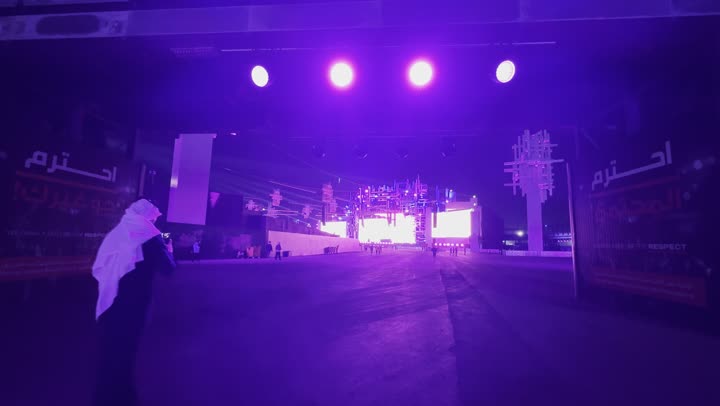 زوار يتجولون وسط أجواء ممتعة ومليئة بالتسلية والترفيه، أجواء ليلية في منطقة الأنشطة الخارجية ، مهرجان ساوندستورم ميدل بيست في منطقة بنبان في مدينة الرياض،  ١٣ ديسمبر ٢٠٢٥  في المملكه العربيه السعوديه ،إضاءة بنفسجية قوية تمتد على المسار المفتوح،تجربة عائلية وشبابية ممتعة ضمن فعاليات موسم الرياض