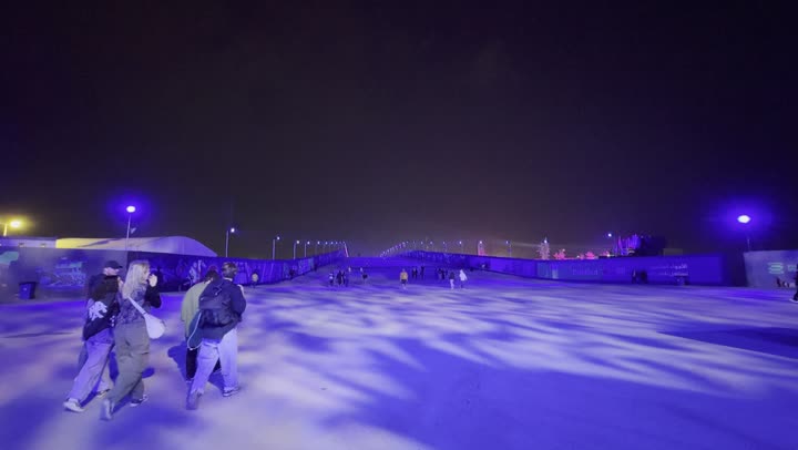 Night atmosphere in the outdoor activities area, Soundstorm Middle Beast Festival in the Binban area of Riyadh, December 13, 2025, in the Kingdom of Saudi Arabia, strong blue lighting extending over the open path, visitors wandering in an enjoyable atmosphere filled with fun and entertainment, a delightful family and youth experience as part of the Riyadh Season events.