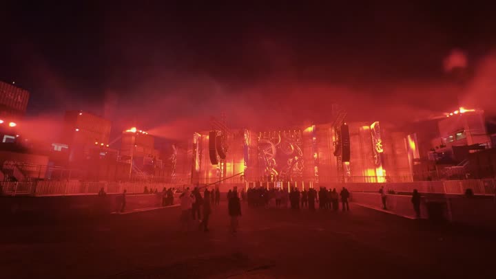 The Soundstorm Middle Beast Festival in the Benban area of Riyadh, a festive night atmosphere, expressions of interaction and integration, December 13, 2025, in the Kingdom of Saudi Arabia, strong red lighting extending over the open path, visitors wandering in an atmosphere filled with fun and entertainment, a delightful family and youth experience as part of the Riyadh Season events.