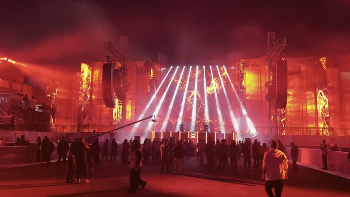 مهرجان ساوندستورم ميدل بيست في منطقة بنبان في مدينة الرياض، أجواء احتفالية ليلية ، تعابير التفاعل والاندماج ، ١٣ ديسمبر ٢٠٢٥ في المملكه العربيه السعوديه ،إضاءة حمراء قوية تمتد على المسار المفتوح، زوار يتجولون وسط أجواء مليئة بالتسلية والترفيه، تجربة عائلية وشبابية ممتعة ضمن فعاليات موسم الرياض